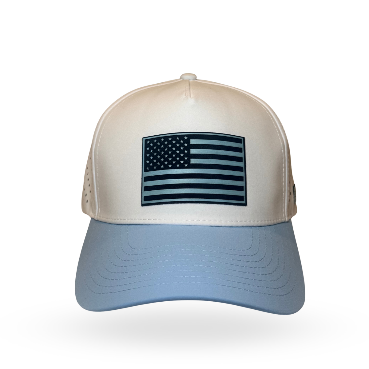 A hybrid baseball cap with a cream-colored front panel, light blue brim, and dark navy blue mesh back panels. The front panel features a rectangular American flag patch in navy blue and white.