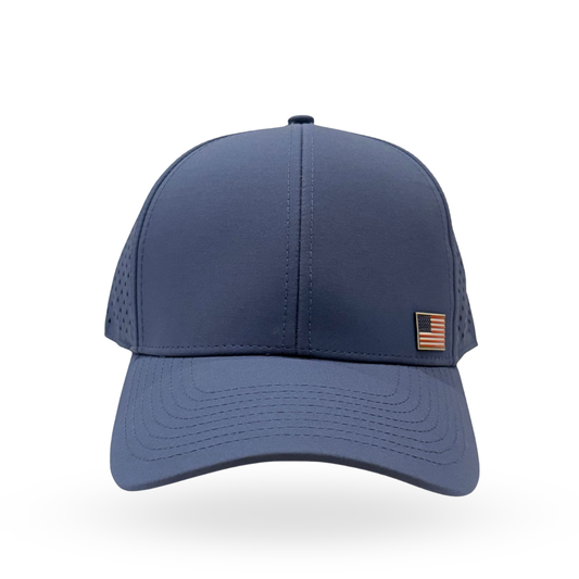 A navy blue baseball cap with a structured front panel, perforated side panels, and a small American flag patch on the side, shown against a plain white background.