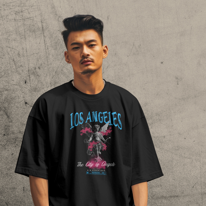 Man wearing a black t-shirt with 'Los Angeles' design against a gray concrete wall