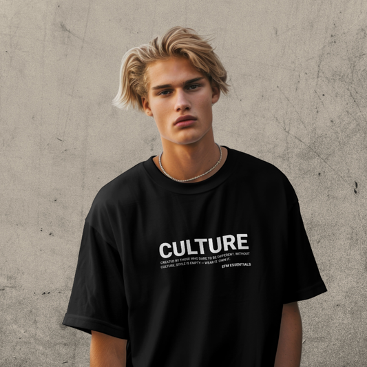 Person wearing a black t-shirt with 'CULTURE' text against a textured wall.