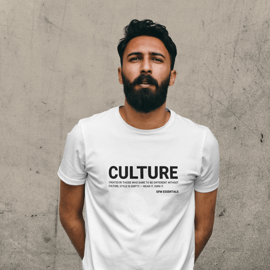Man wearing a white t-shirt with 'CULTURE' text against a textured wall.