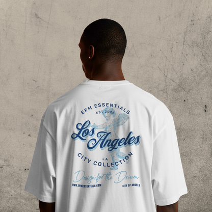 Person wearing a white t-shirt with 'Los Angeles' text and branding on the back, standing against a concrete wall.